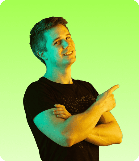 Web-Designer-Picpng - Corporate video production company in Delhi Man in a black T‑shirt crosses his arms and points to the right, smiling against a lime gradient background.